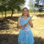 Carrie Krueger in a field holding her flute