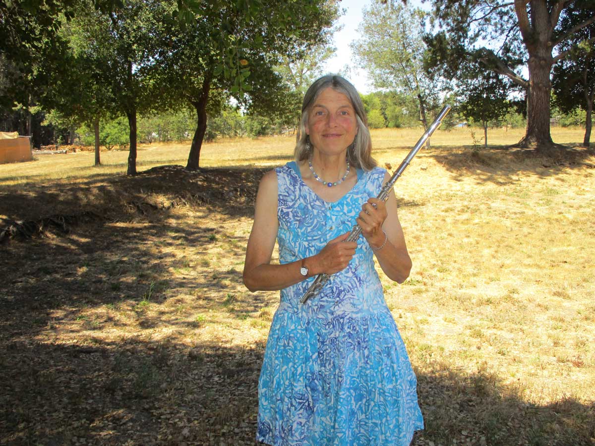Carrie Krueger in a field holding her flute